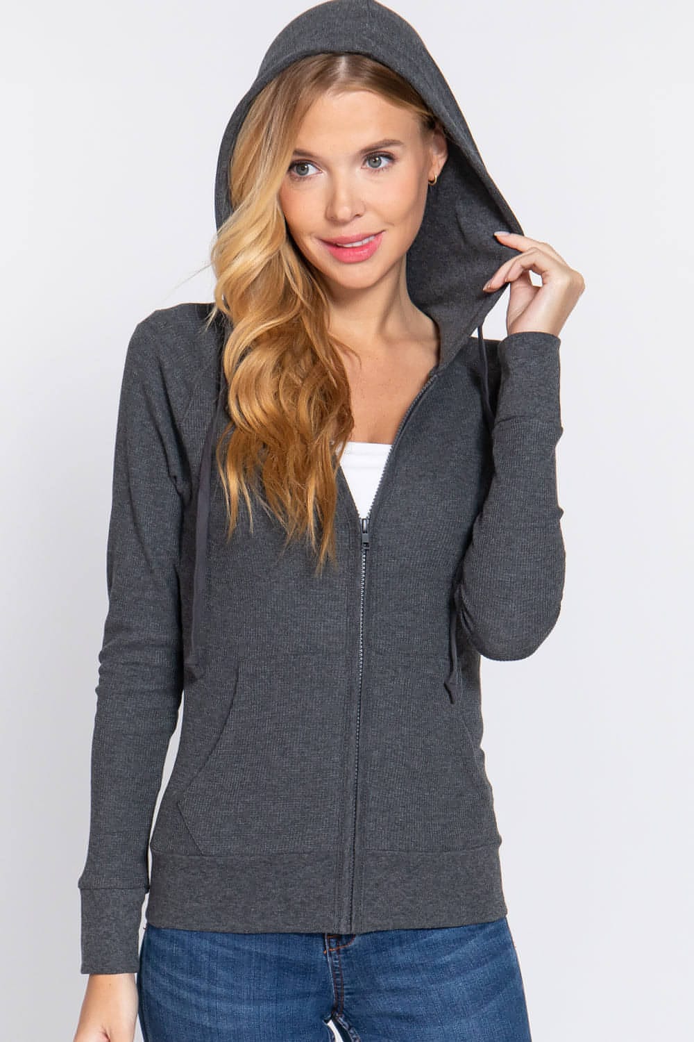 a woman wearing a gray hoodie and jeans